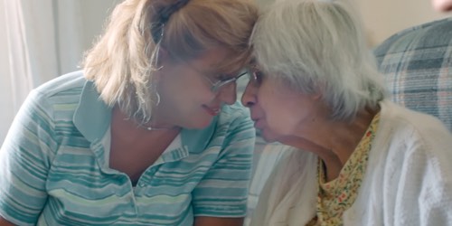 Younger woman and an older woman in close embrace  Younger woman and an older woman in close embrace